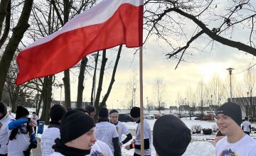 Uczestnicy biegi z flagą Polski